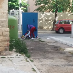 Una donna rom svuota buste e lascia in terra indumenti