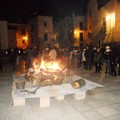 La gente si scalda al fuoco in piazza Meschino