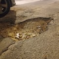 Buca stradale profonda all'uscita del parcheggio di via Fossato