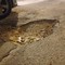 Buca stradale profonda all'uscita del parcheggio di via Fossato